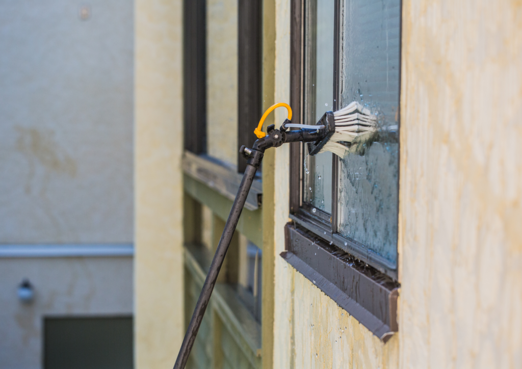 cleaning a window using water fed pole brush